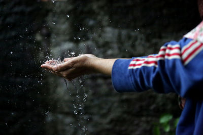 Midsection of person enjoying rain