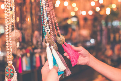 Cropped hands of woman holding decoration in display at store