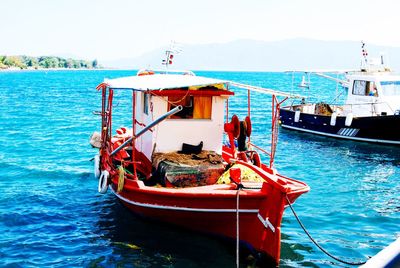 Rear view of people sailing in sea against sky