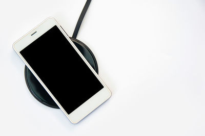 High angle view of smart phone against white background