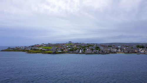 Buildings in city against cloudy sky