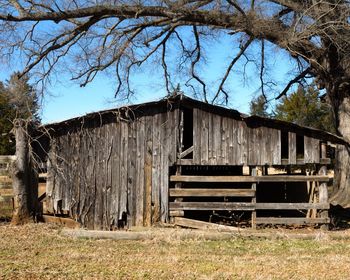 Abandoned barn on field against sky