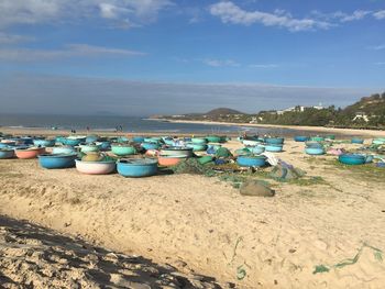 Deck chairs on beach against sky