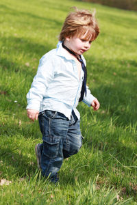 Boy walking on grassy field