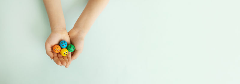 Cropped hand of woman holding toy against white background