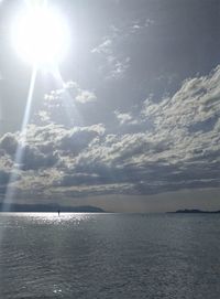 Scenic view of sea against bright sun