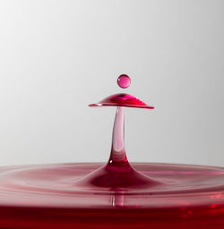 Close-up of water drop on red surface