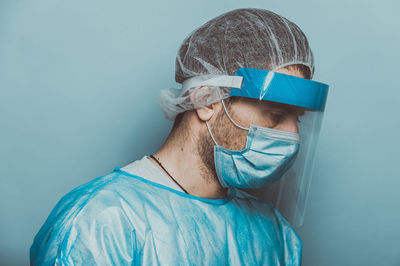 Portrait of young man against blue wall