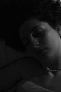 Close-up of young woman lying on bed at home