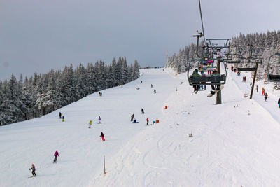 People enjoying on snow covered landscape