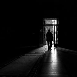 Silhouette man walking in corridor