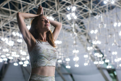 Smiling woman with hands clasped doing yoga