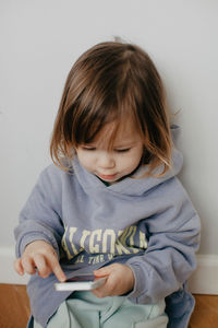 Portrait of cute girl sitting on bed at home