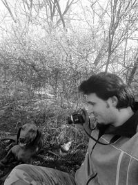 Man photographing through smart phone and tree