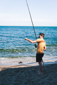 Full length of man standing on beach against sky