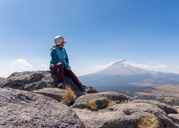 Woman sitting on rock outdoors