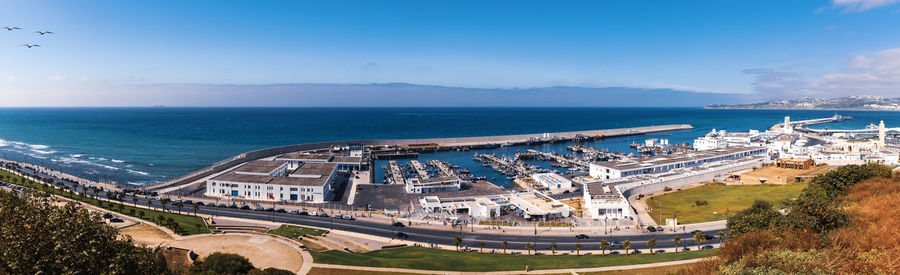 Panoramic shot of sea and cityscape against sky