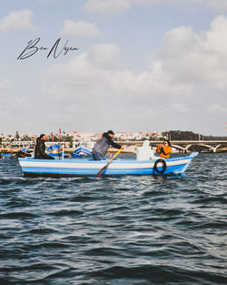 People on boats in sea against sky