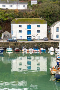 Boats moored on river by buildings