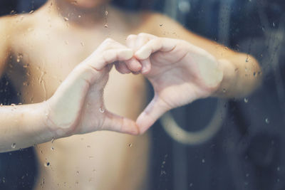 Close-up of woman hands on wet glass