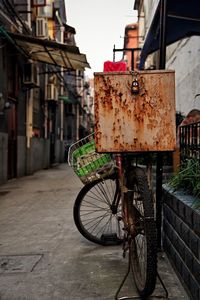 Abandoned container on bicycle back seat at footpath