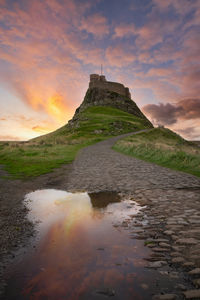 Scenic view of sea against cloudy sky during sunset