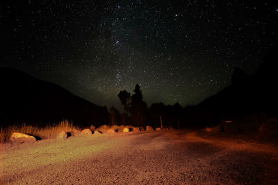  dirt road against star field in sky at night