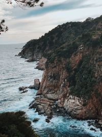 Rock formations by sea against sky