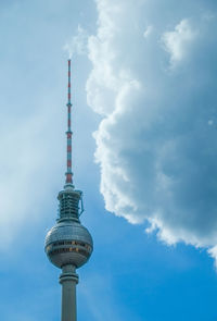 Low angle view of communications tower against cloudy sky