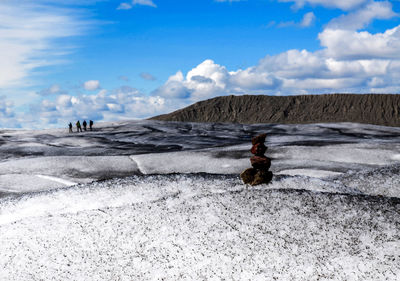 People on mountain against sky