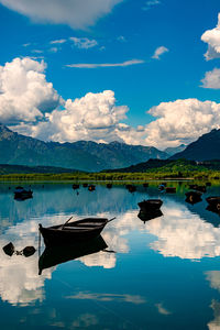 Boats moored in lake against sky