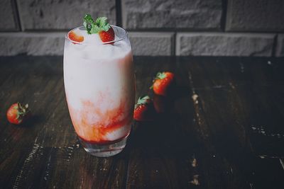 Close-up of fresh strawberry milkshake on table