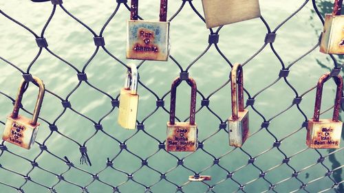 Close-up of padlocks on chainlink fence