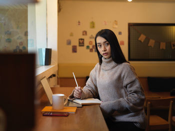 Portrait of woman sitting on table