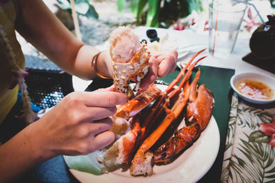 Midsection of woman eating crab in restaurant