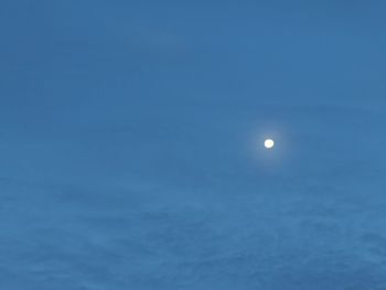 Low angle view of moon against blue sky
