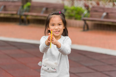 Portrait of smiling girl holding outdoors