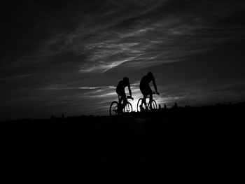 Silhouette of people riding bicycle