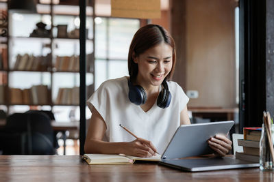 Young businesswoman using laptop at cafe