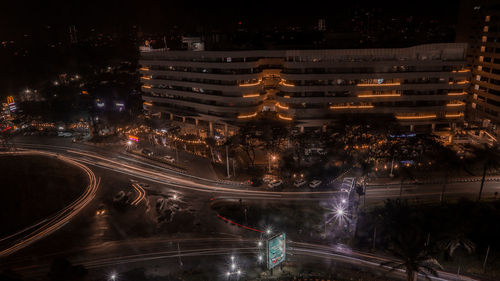 High angle view of illuminated city street and buildings at night