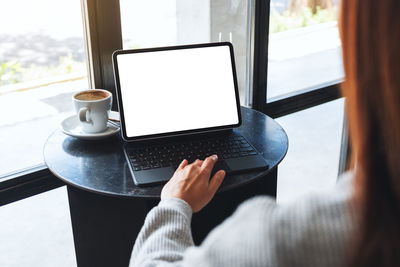 Mockup image of a woman touching on tablet touchpad with blank white desktop screen as a computer pc