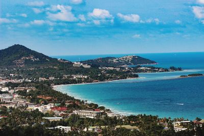 Aerial view of city by sea against sky