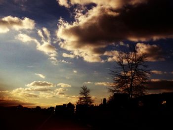 Silhouette of trees against cloudy sky