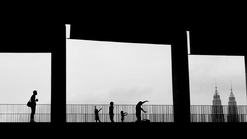 Silhouette people standing against clear sky