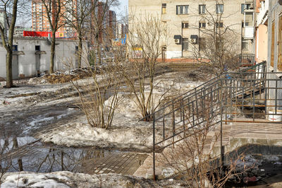 Frozen river amidst buildings in city during winter