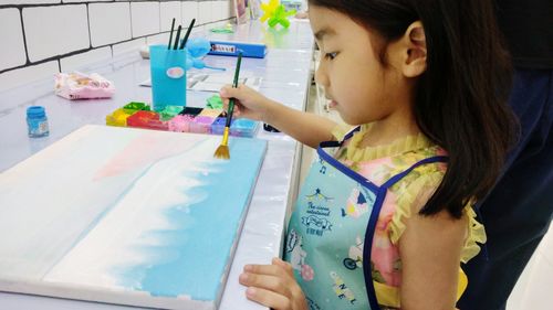 The girl is learning to paint the pictures of the sea