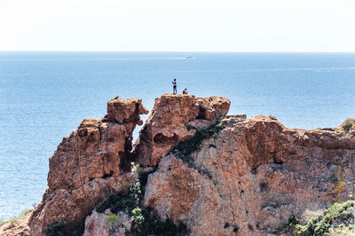 Rock formations by sea against sky