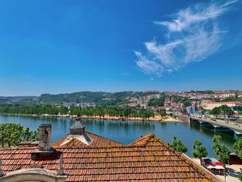 Houses by river against blue sky