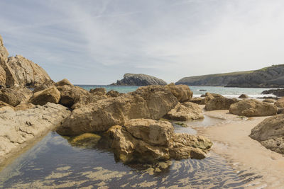 Rocks in sea against sky