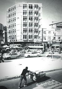 People on street against buildings in city